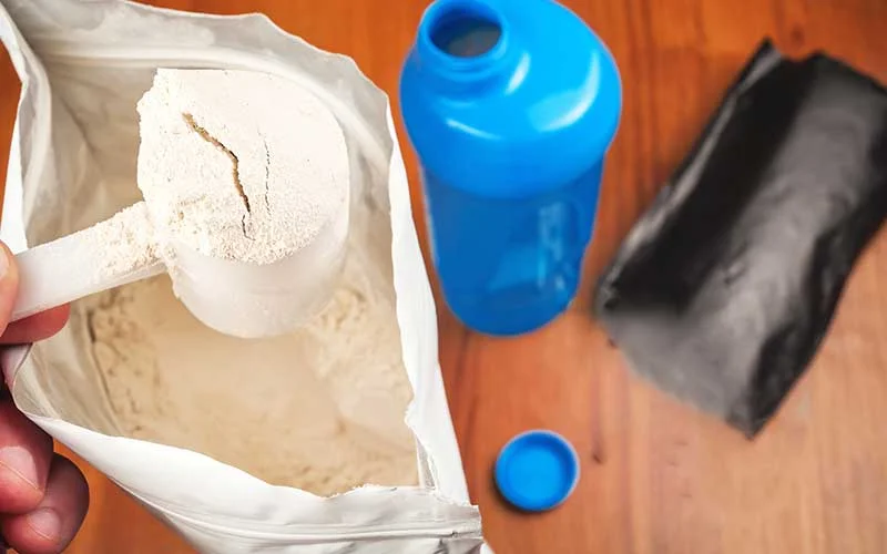 shaker and meal replacement shake powder in a paper bag with a scoop