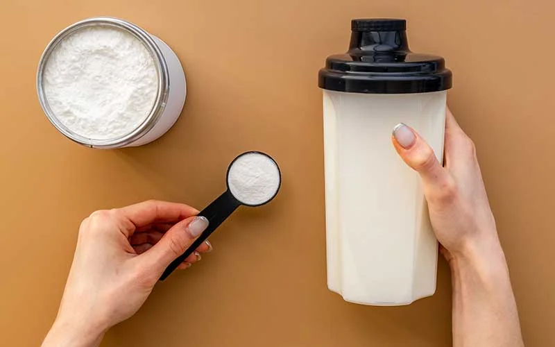 Hands holding meal replacement shake powder in scoop