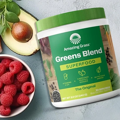 Amazing Grass Greens Blend Superfood, avocado, and strawberries on gray background