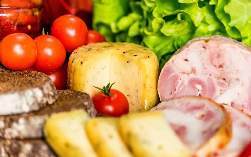 cheese, meat, tomatoes, lettuce and other foods in kitchen