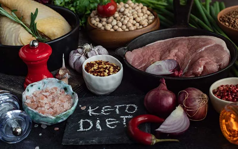 Ingredients for ketogenic diet. Meat, vegetables and spices on a black background